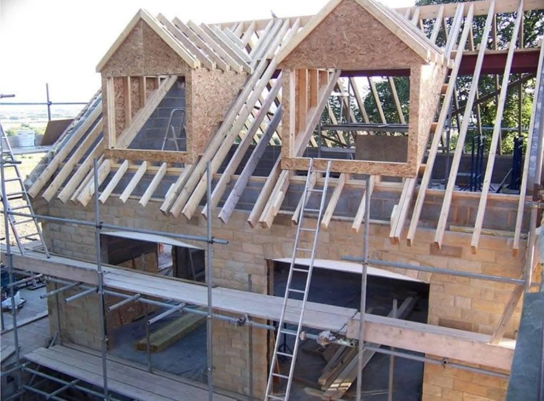 Surélévation : charpente bois et lucarnes en cours de montage sous échafaudage
