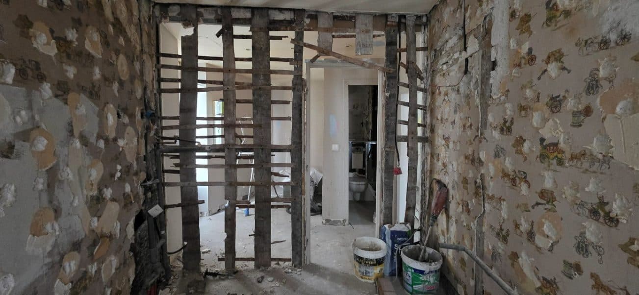 Mur intérieur mis à nu dans un immeuble du XIXe siècle : montants et traverses en bois avant ouverture